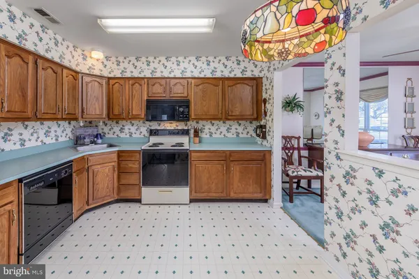 a kitchen with stainless steel appliances a stove a sink a microwave a refrigerator and cabinets