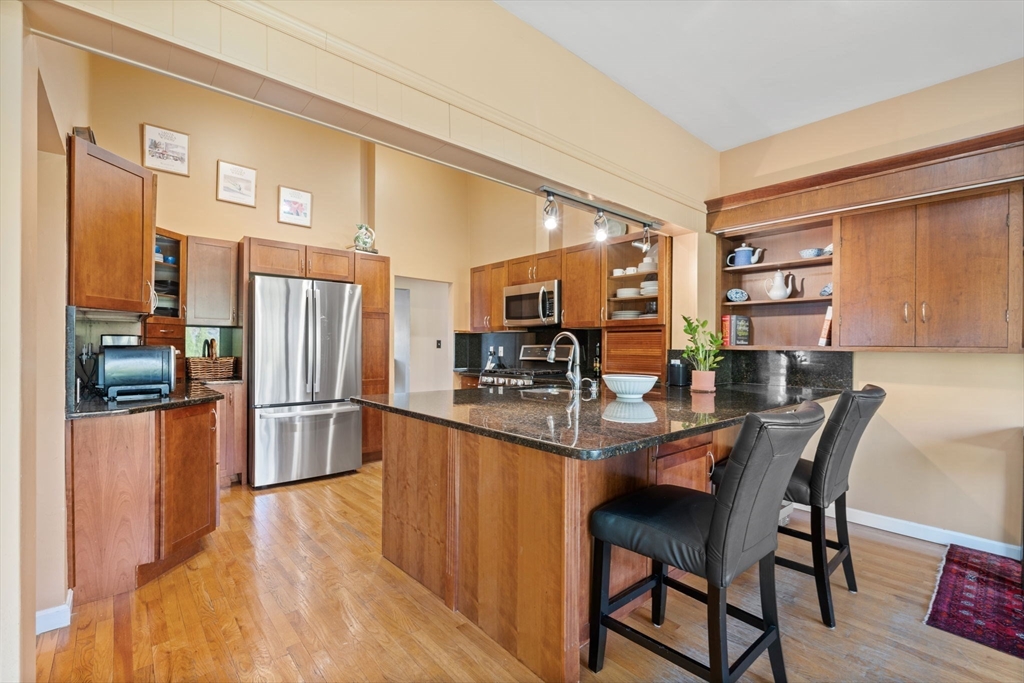 42 Stanley Road Newton, MA 02468 - Photo 3 of 29 a kitchen with stainless steel appliances a dining table chairs refrigerator and sink