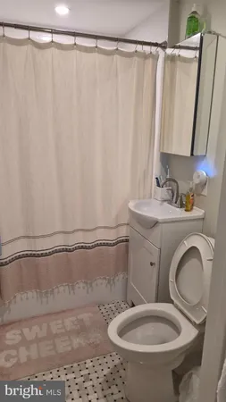 a bathroom with a sink a toilet and a mirror