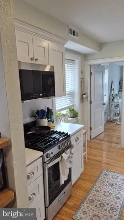 a kitchen with stainless steel appliances a stove a microwave and cabinets