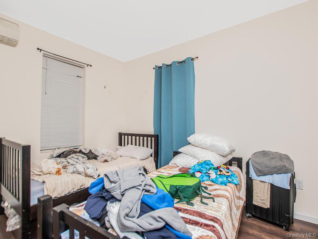 1406 White Plains Road Bronx, NY 10462 - Photo 16 of 43 a bedroom with furniture and a wooden floor