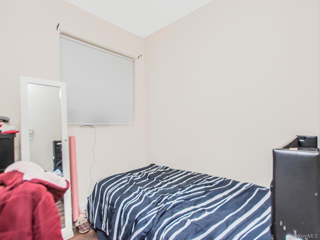 1406 White Plains Road Bronx, NY 10462 - Photo 18 of 43 a bedroom with a bed and a night stand