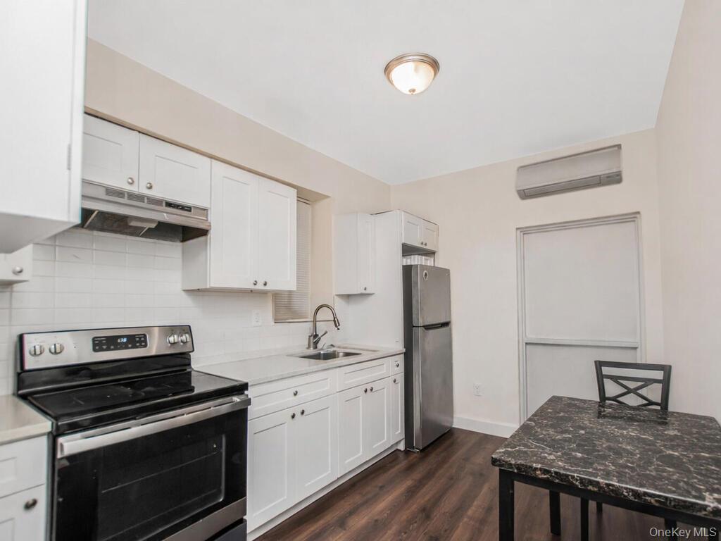 1406 White Plains Road Bronx, NY 10462 - Photo 39 of 43 a kitchen with stainless steel appliances granite countertop a stove a sink and a refrigerator