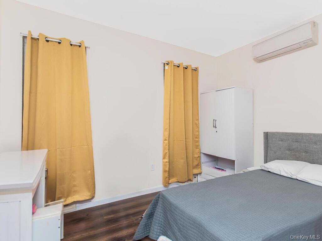 1406 White Plains Road Bronx, NY 10462 - Photo 41 of 43 a bedroom with a bed and wooden floor
