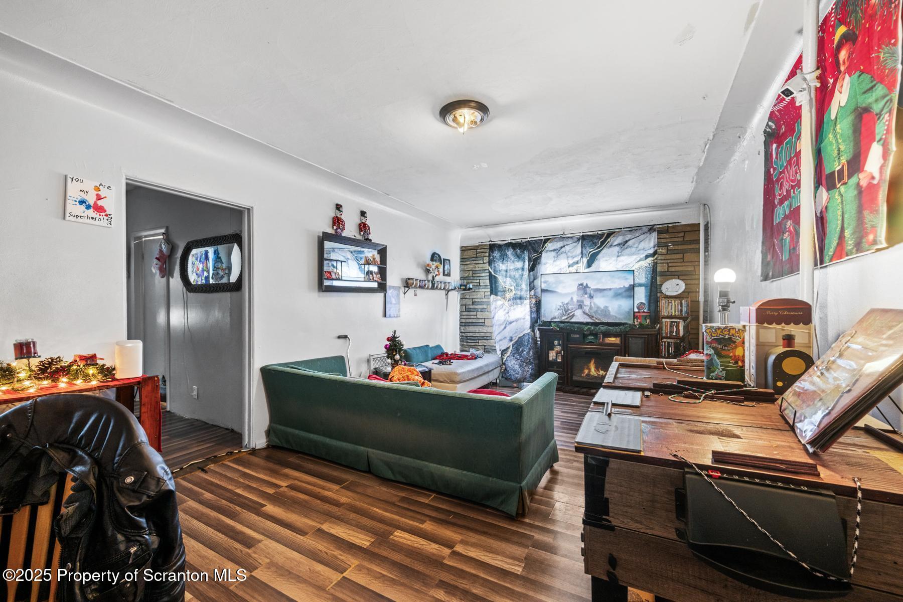 1024 South Webster Avenue Scranton, PA 18505 - Photo 14 of 38 a living room with furniture a flat screen tv and a floor to ceiling window
