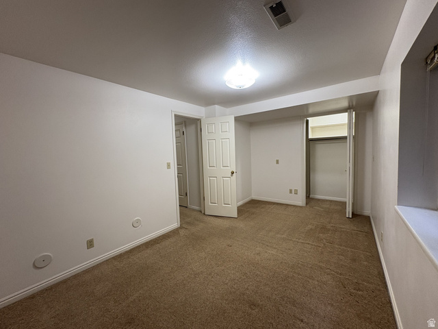 486 West 120 North Orem, UT 84057 - Photo 19 of 30 Carpeted room featuring white walls, white trim, a flush-mount ceiling light, a built-in closet with bifold doors, and a window well