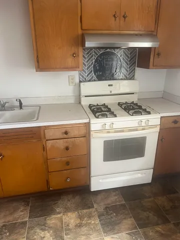 a kitchen with a stove top oven and cabinets