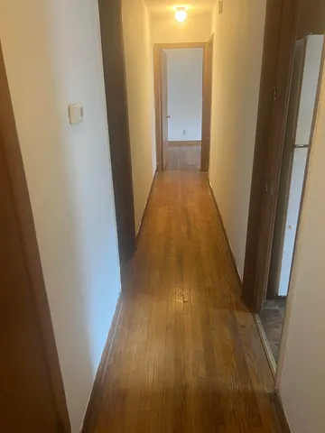 a view of a hallway with wooden floor
