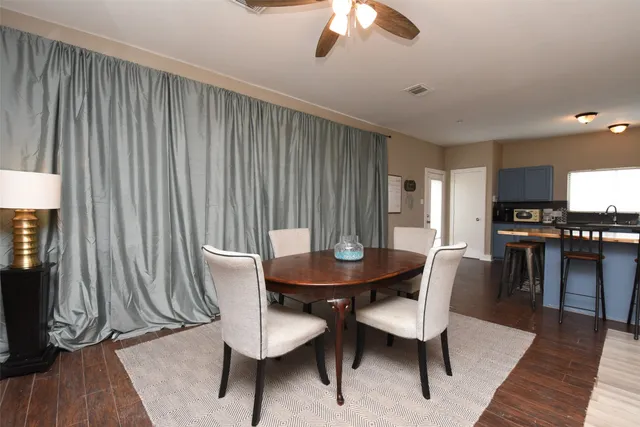 a kitchen with granite countertop a dining table chairs and a refrigerator
