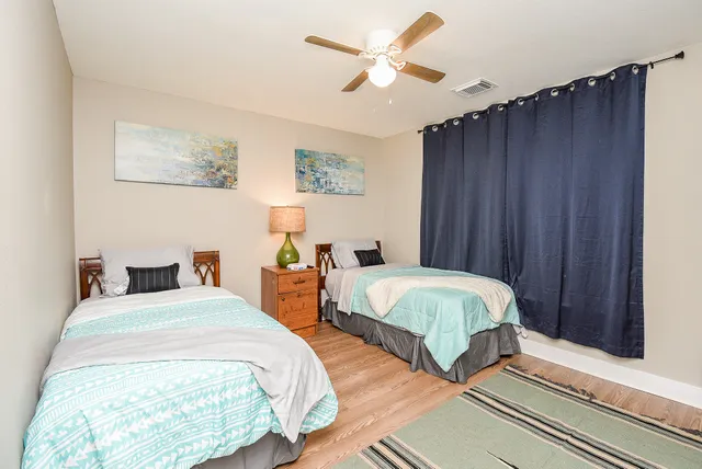 a bedroom with two beds and a chandelier