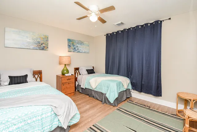 a spacious bedroom with two beds and a chandelier