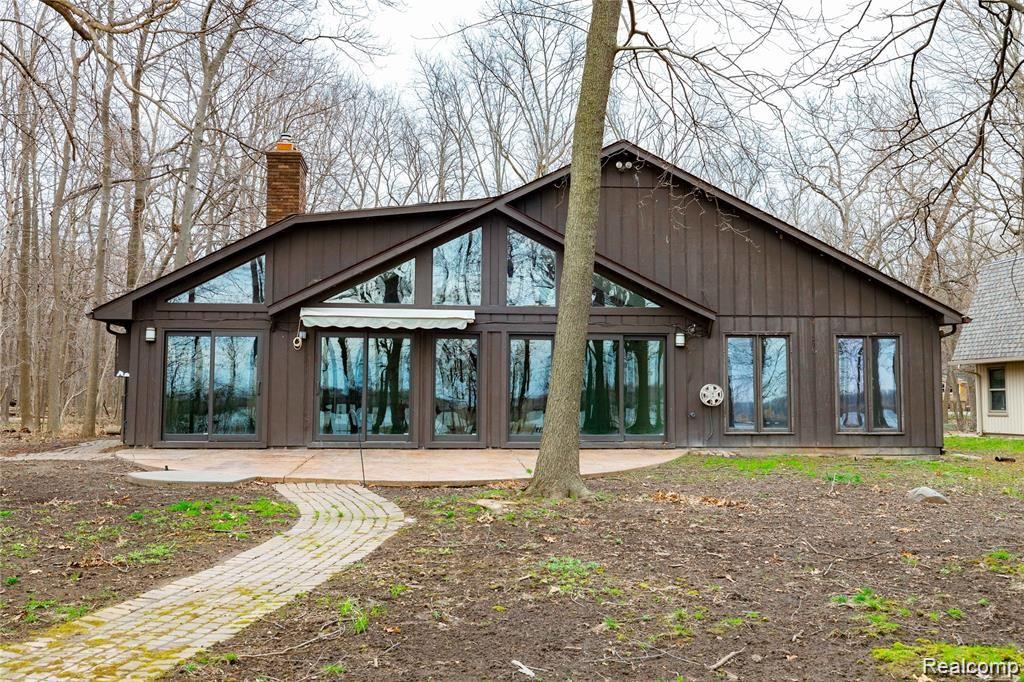 19130 Meridian Road Grosse Ile, MI 48138 - Photo 40 of 49 Rear view of home shows the stamped concrete patio and the multitude of windows.