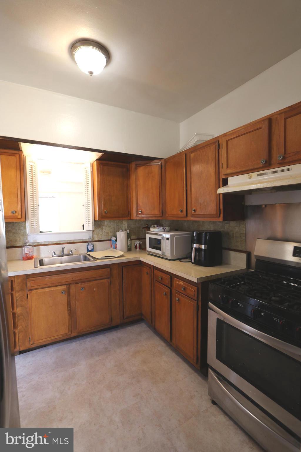 2038 34th Street Southeast Washington, DC 20020 - Photo 12 of 32 a kitchen with stainless steel appliances granite countertop a stove a sink and a refrigerator