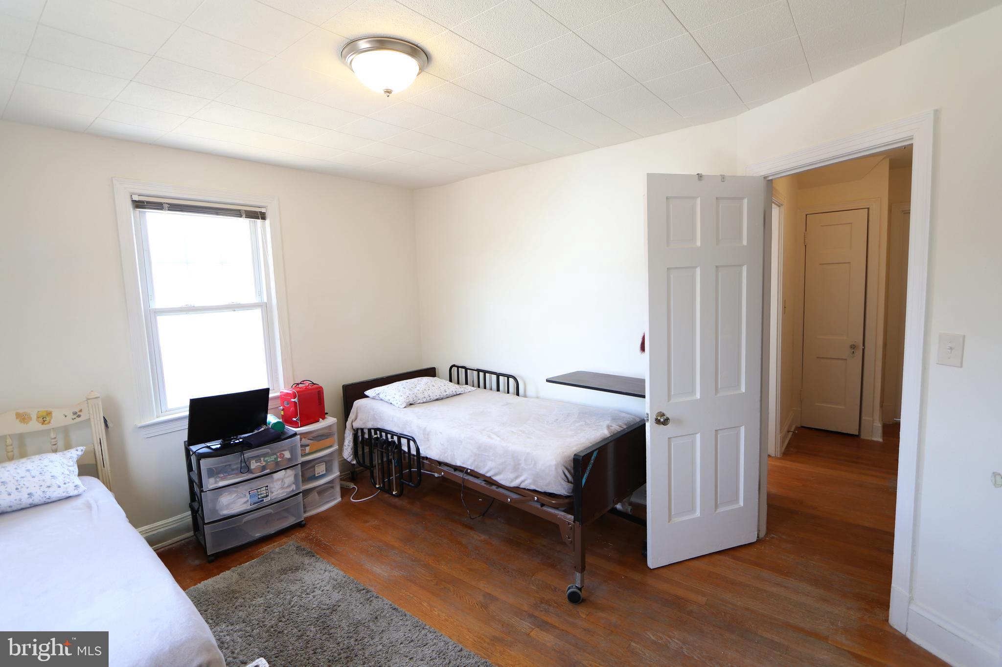 2038 34th Street Southeast Washington, DC 20020 - Photo 26 of 32 a bedroom with a bed and wooden floor