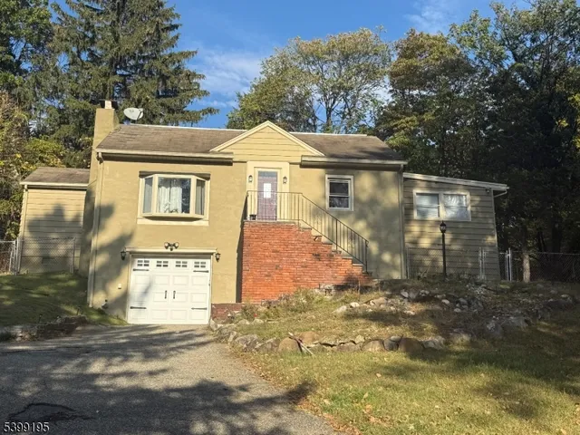 a view of a white house with large windows and a small yard