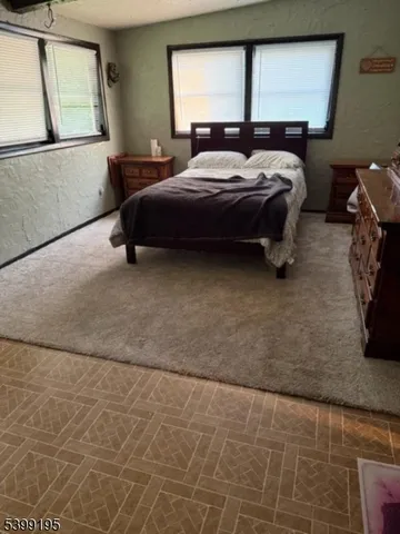 a bed sitting in a bedroom next to a window