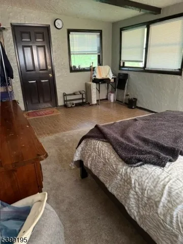 a bedroom with a bed and large windows