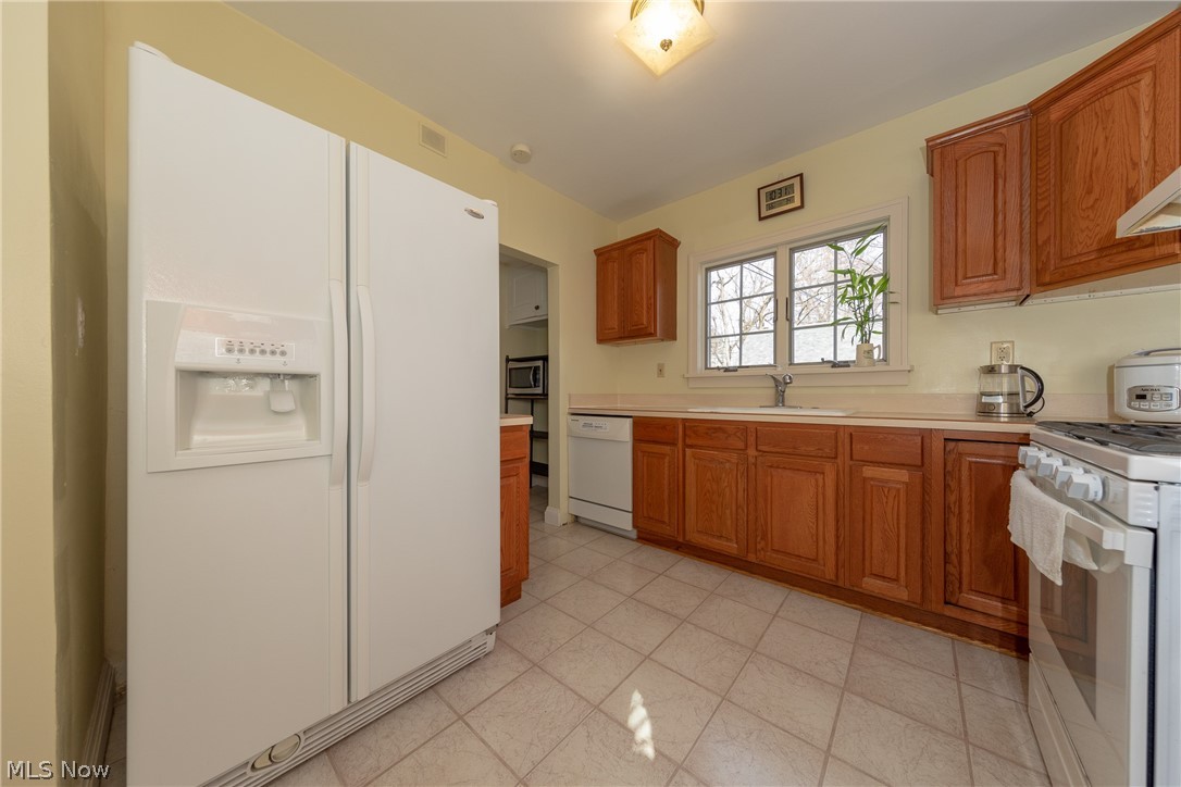 16629 Fernway Road Cleveland, OH 44120 - Photo 11 of 30 The Kitchen with white appliances and plenty of cabinets for all your storage needs