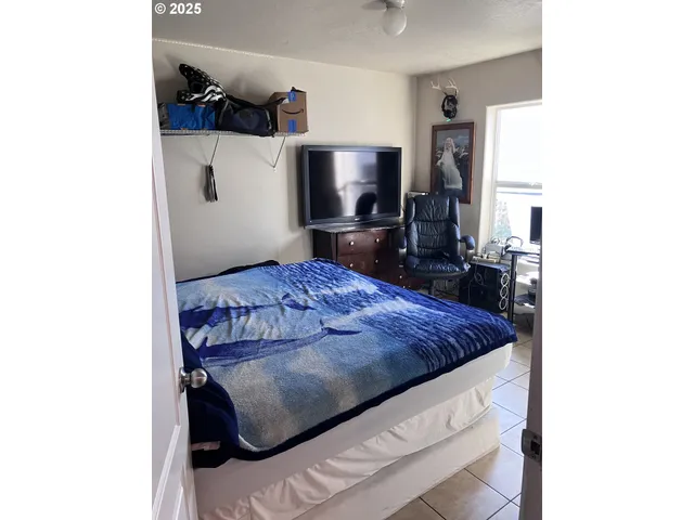 a living room with a bed furniture and a flat screen tv