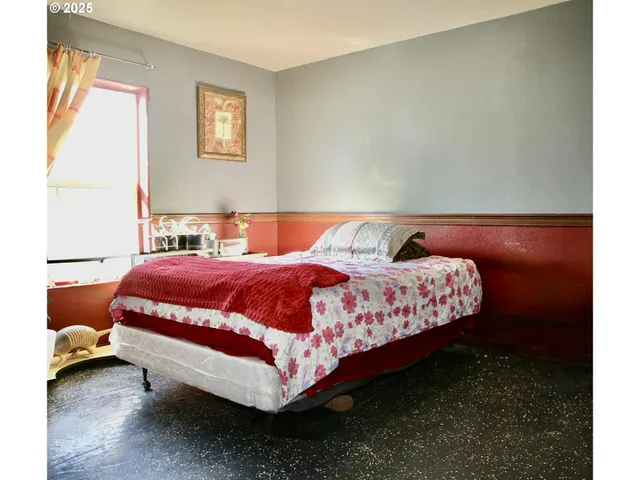 a bed sitting in a bedroom next to a window