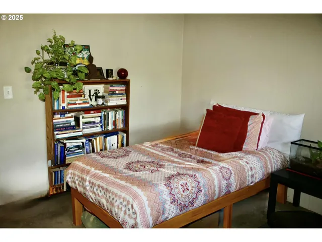 a bedroom with a bed a book shelf and a shelf