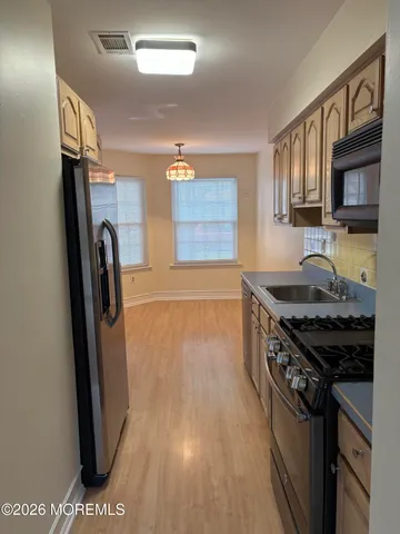 a kitchen with granite countertop a refrigerator a stove and a sink