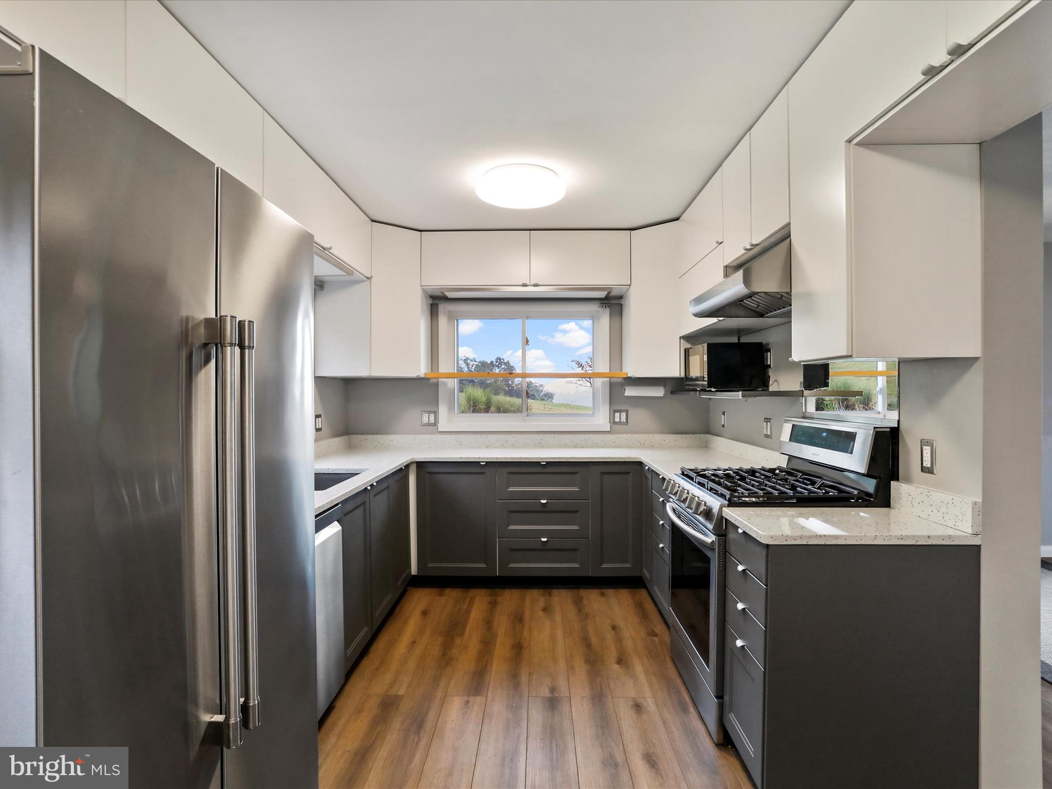 9475 Waxler Road Keyser, WV 26726 - Photo 18 of 61 a kitchen with stainless steel appliances granite countertop a refrigerator a sink dishwasher a stove and white countertops with wooden floor