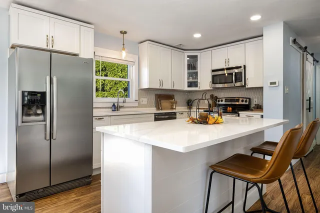 a kitchen with stainless steel appliances a refrigerator sink and microwave