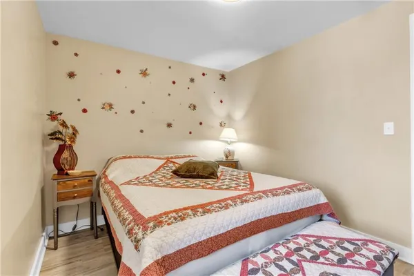 a bedroom with a bed and a chair with potted plants