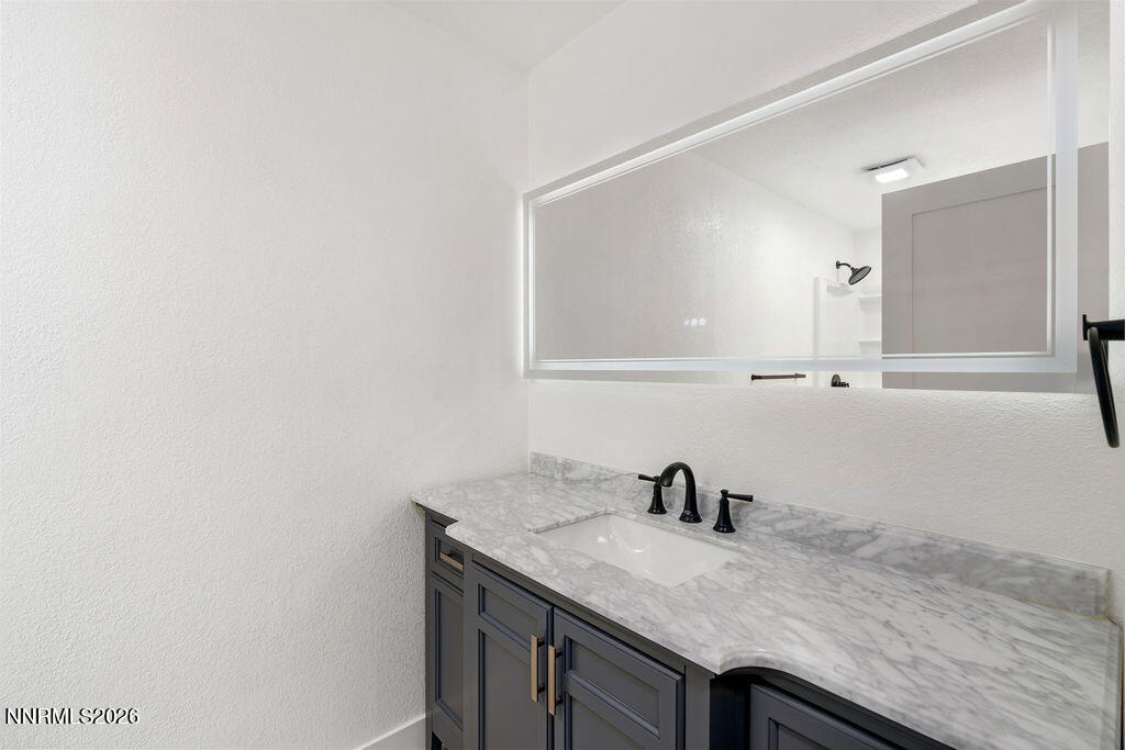 4804 Pinesprings Drive Reno, NV 89509 - Photo 16 of 32 a bathroom with a granite countertop sink and a mirror