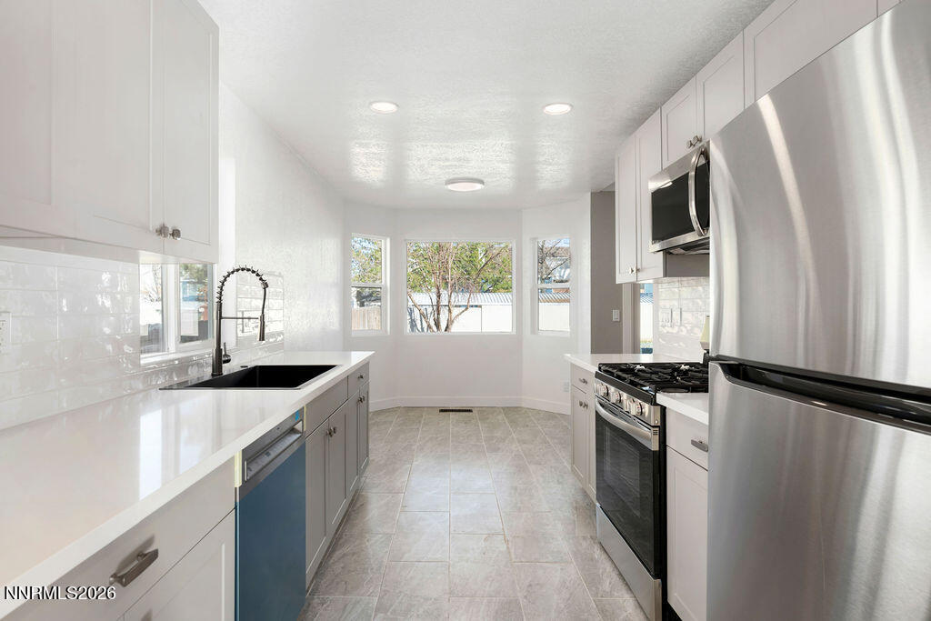 4804 Pinesprings Drive Reno, NV 89509 - Photo 8 of 32 a kitchen with granite countertop a sink stove and refrigerator