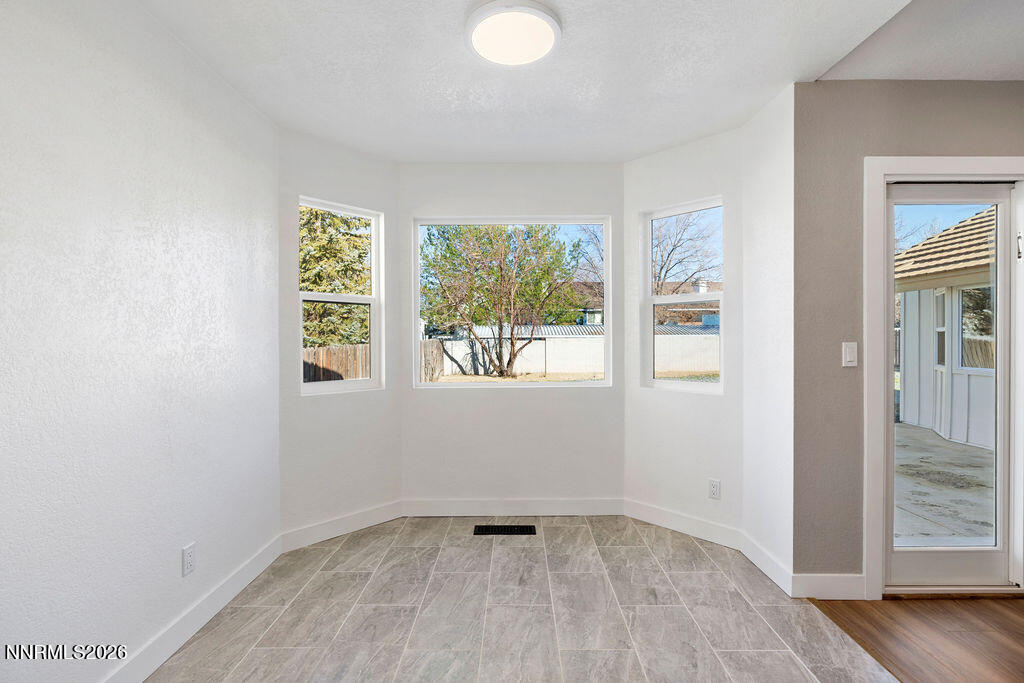 4804 Pinesprings Drive Reno, NV 89509 - Photo 10 of 32 an empty room with wooden floor and windows