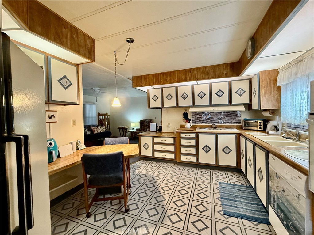 4878 Leonard Road, Unit 11 Mariposa, CA 95338 - Photo 6 of 15 a large white kitchen with stainless steel appliances kitchen island granite countertop a refrigerator and a stove