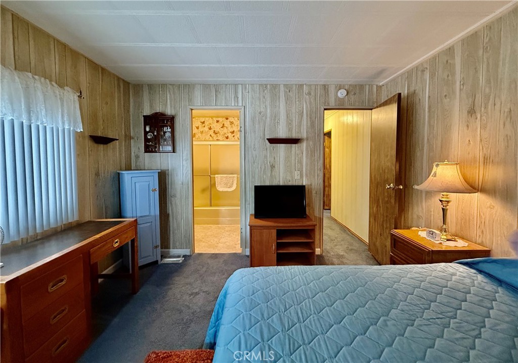 4878 Leonard Road, Unit 11 Mariposa, CA 95338 - Photo 9 of 15 a bedroom with a bed flat screen tv and a dresser