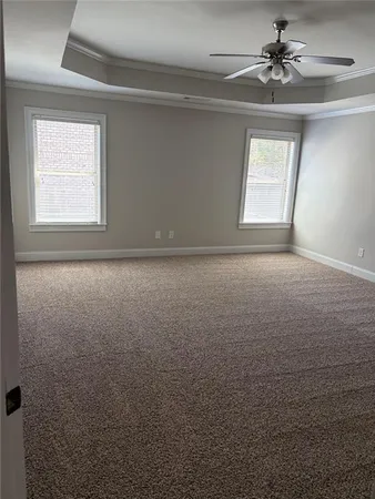 en empty room with windows and chandelier fan
