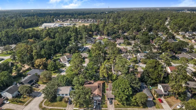 an aerial view of a residential houses covered in trees