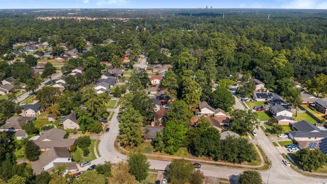 an aerial view of residential houses with outdoor space and trees
