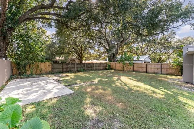 a view of yard with tree and wooden fence
