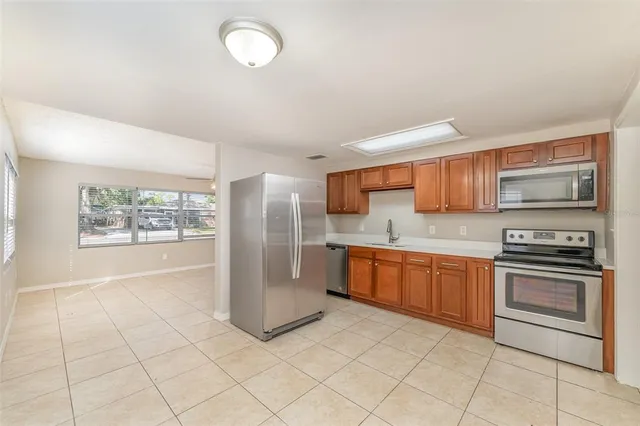 a large kitchen with stainless steel appliances granite countertop a stove a sink and a refrigerator