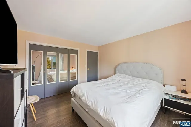 a bedroom with a bed and a flat tv screen on dresser