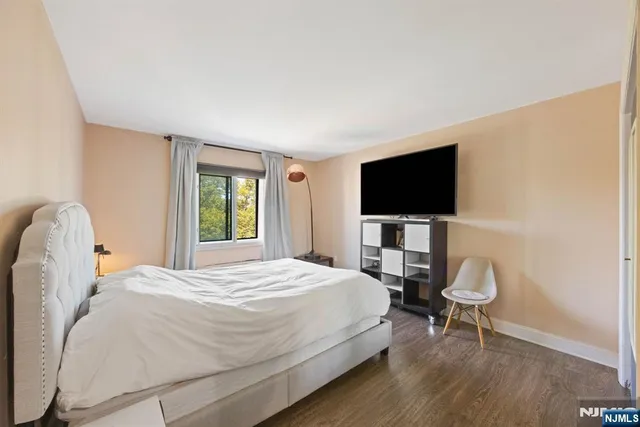 a bedroom with a bed tv and a chair