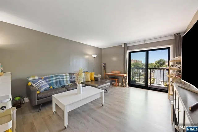 a living room with furniture and a flat screen tv with wooden floor