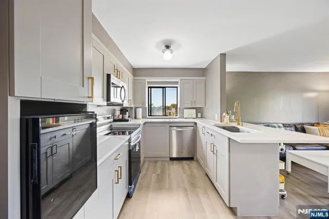 a kitchen with a sink a stove top oven and cabinets