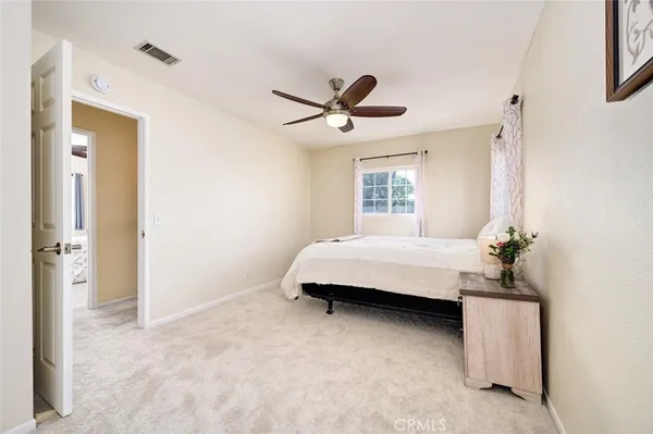 a spacious bedroom with a bed and a chandelier