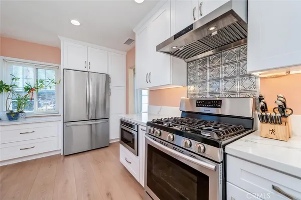 a kitchen with appliances and wooden floor