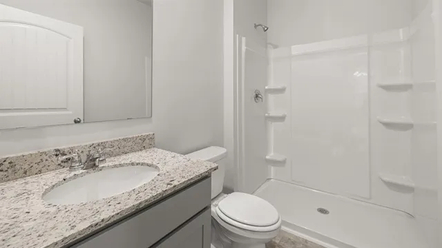 a bathroom with a granite countertop sink toilet and shower