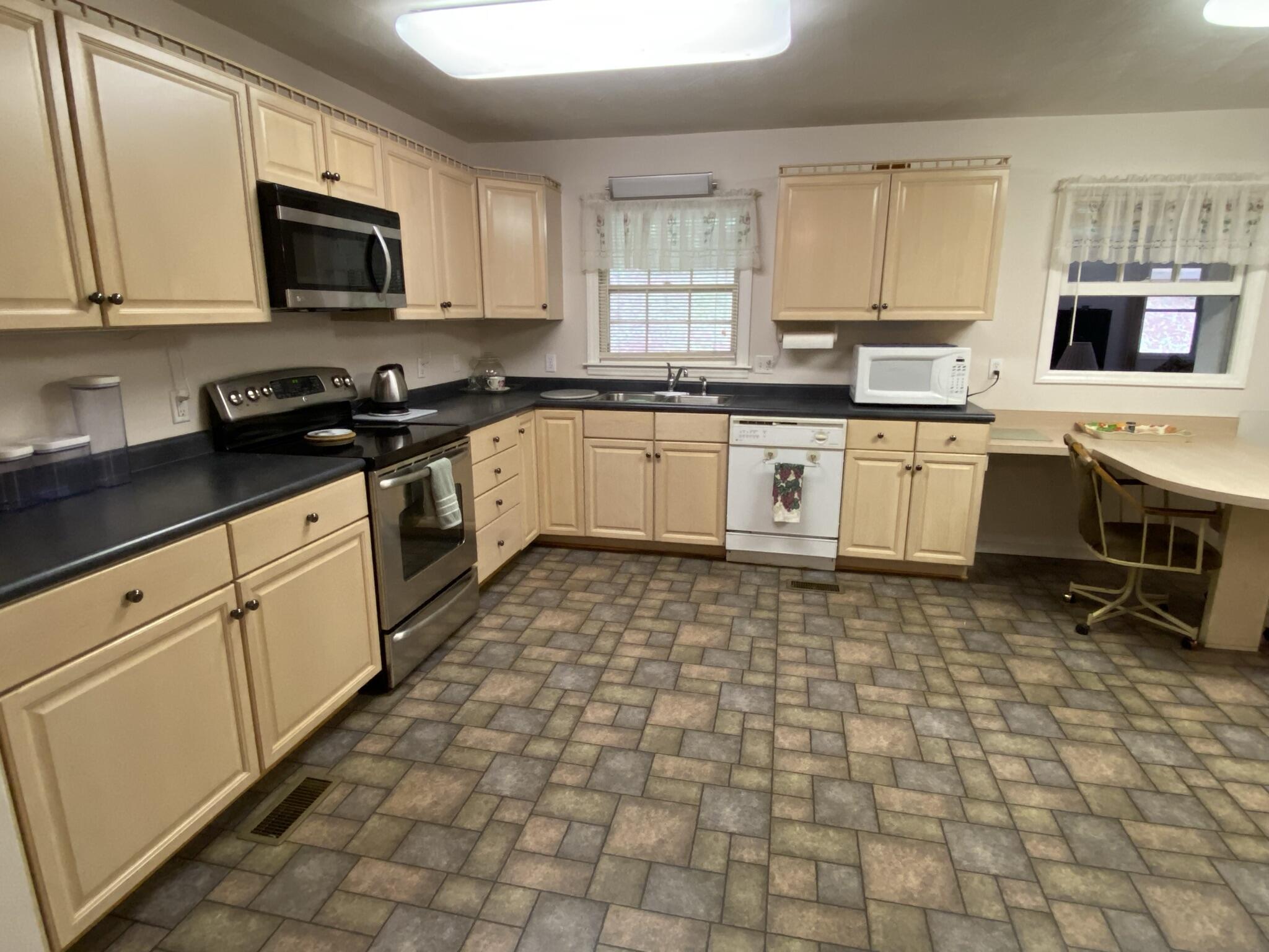 5378 Ferrum Mountain Road Callaway, VA 24067 - Photo 8 of 71 a large kitchen with a stove a sink a microwave and cabinets