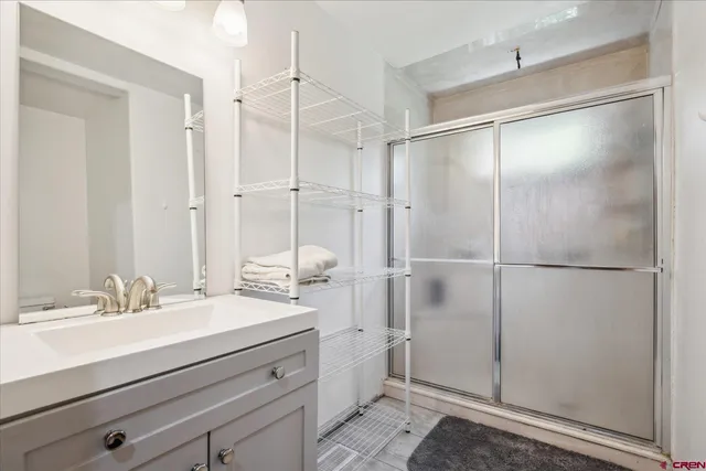 a bathroom with a shower sink vanity and mirror