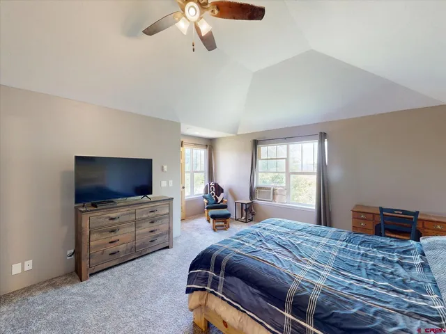 a bedroom with bed and tv with window