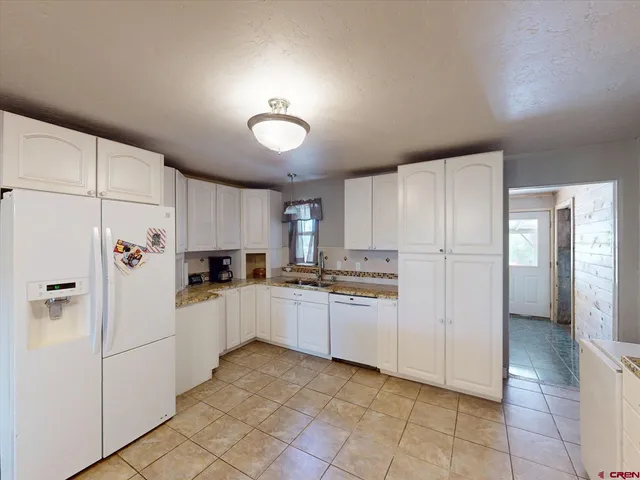 a kitchen with white cabinets and white appliances